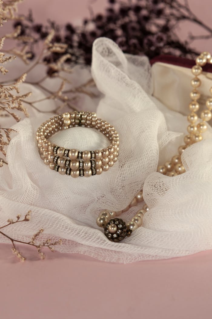 gallery-01 Sophisticated display of pearl jewelry on soft white fabric, perfect for luxury fashion and design inspirations.